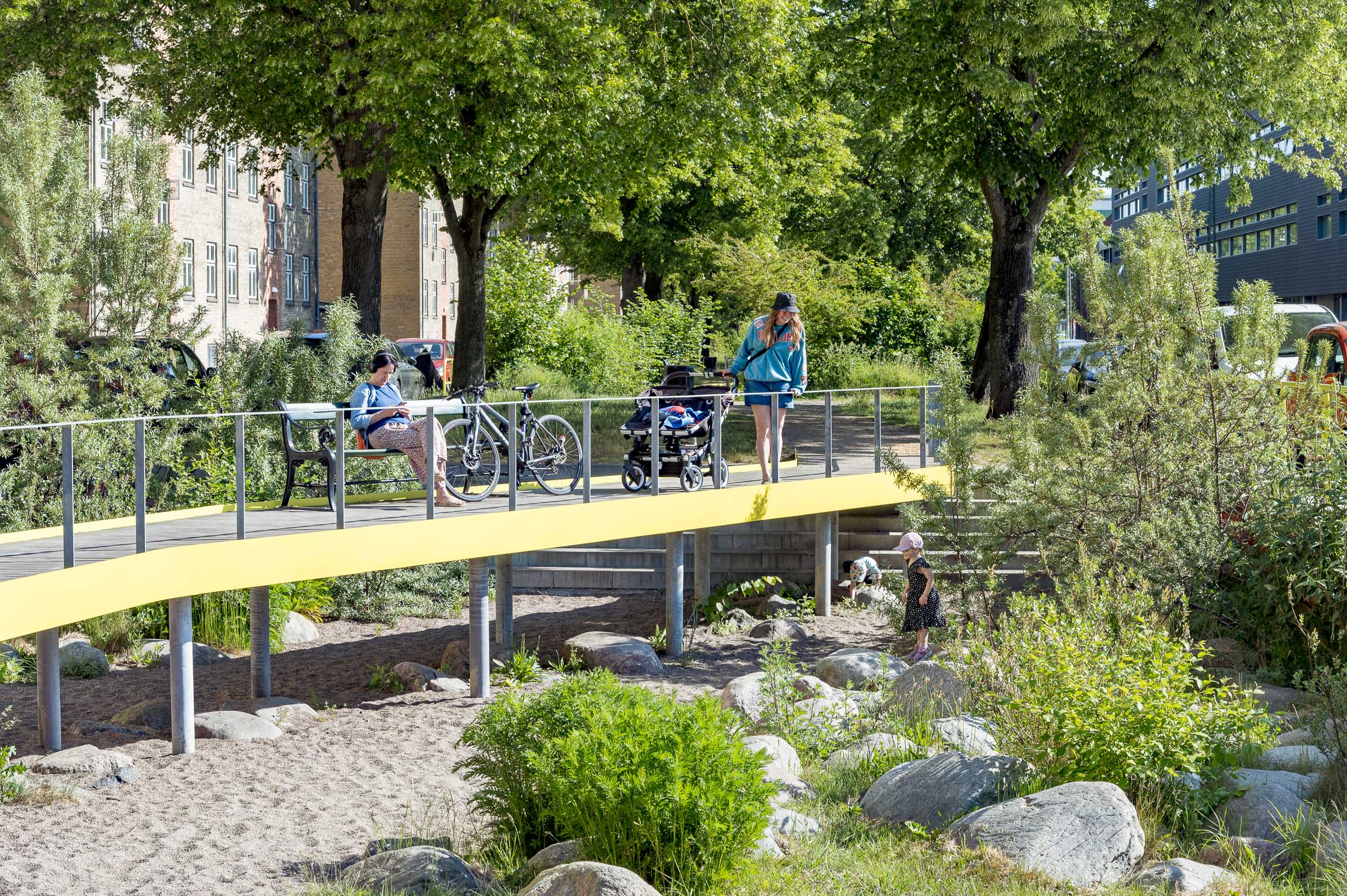 foto van mensen op brug tussen gebouwen in de zon