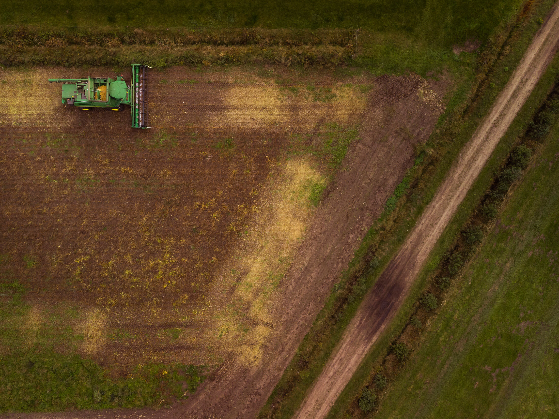 tractor in veld maait weiland foto van bovenaf