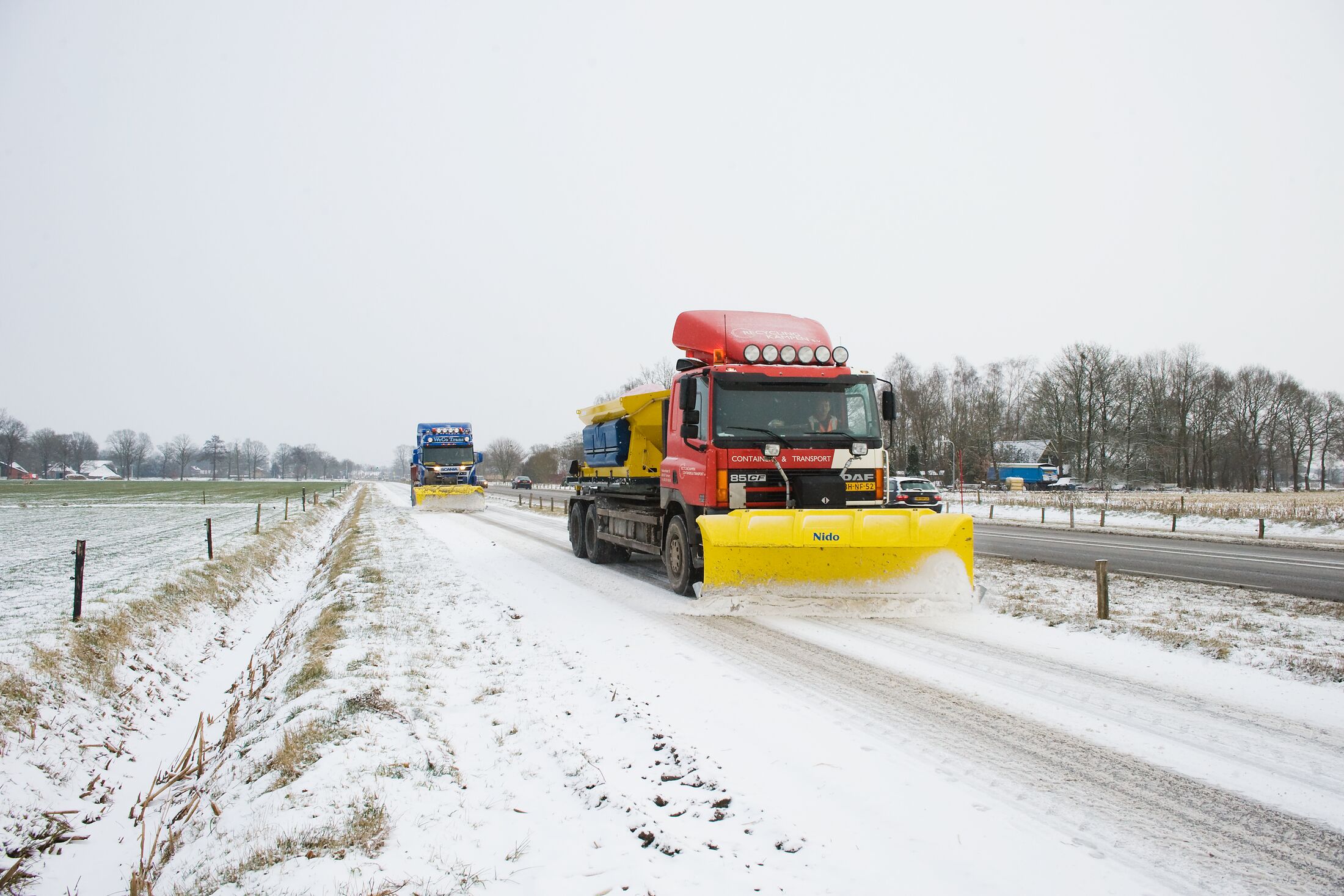 Sneeuwschuivers op de weg met sneeuw