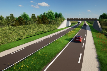 Een viaduct omringt door groene bermen en bomen met twee eenverkeerswegen die eronderdoor lopen